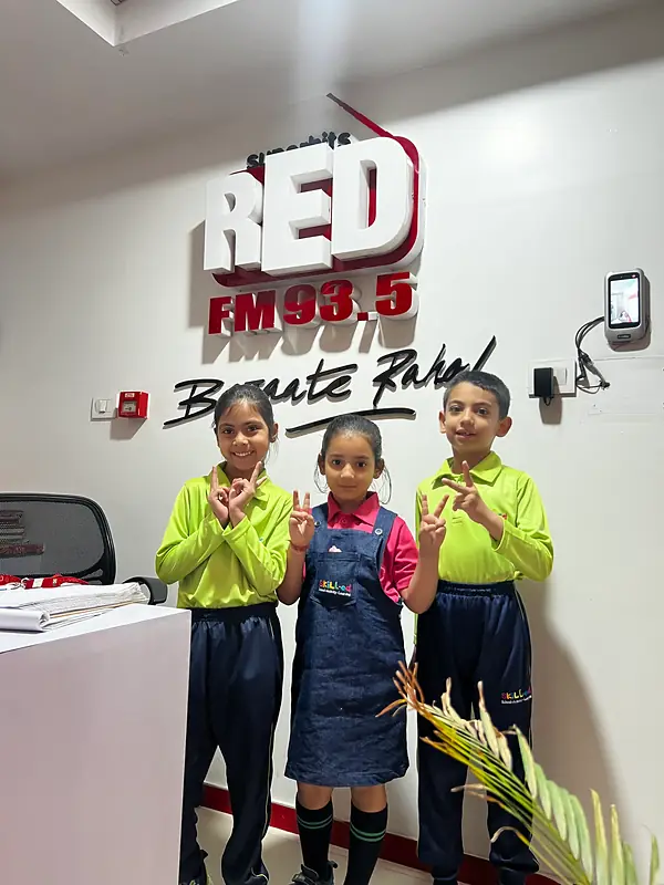 Three students smiling at the RED FM 93.5 studio