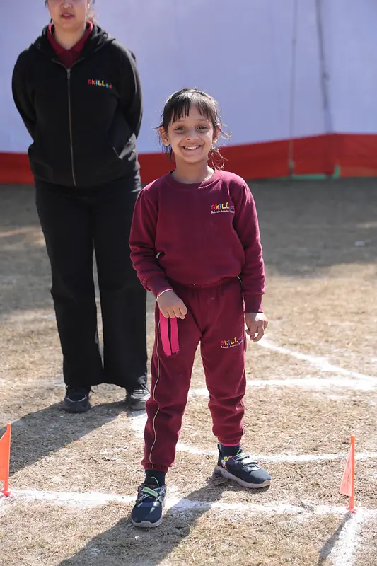 A student beaming on the field at the 10th Annual Sports Day