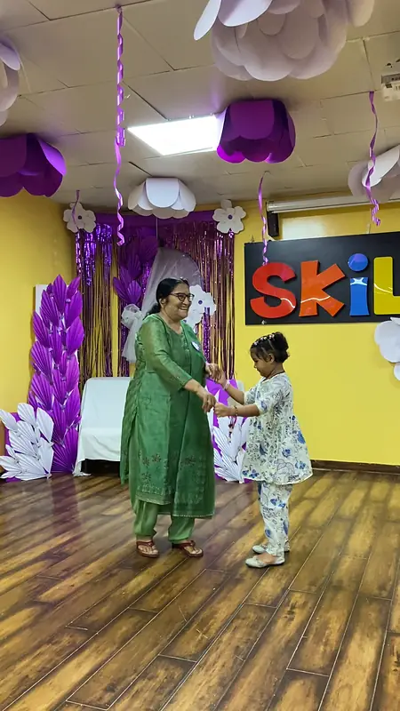 A grandmother and grandson dance on the hall floor