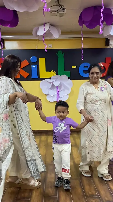 A grandson dances hand in hand with two grandmothers